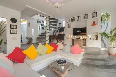 a living room with a white couch with colorful pillows at PROMO Modern Seminyak Pvt Villa with Pool and Parking in Seminyak
