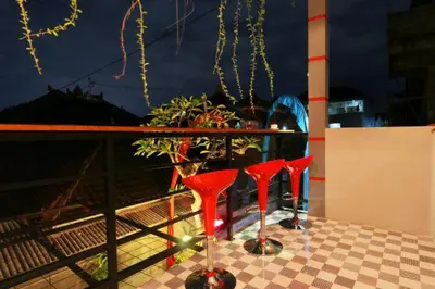 two red stools sitting on a table on a balcony at Valomia Guest House in Kerobokan