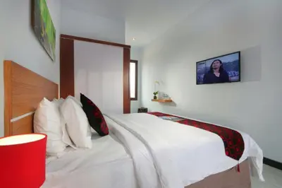 a bedroom with a large white bed in a room at Valomia Guest House in Kerobokan