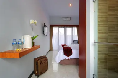 a hotel room with a bed and a window at Valomia Guest House in Kerobokan