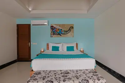 a bedroom with a large bed with blue walls at Lacasa2 Villa Legian With Butler in Legian