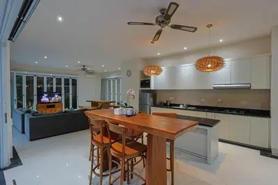 a kitchen and living room with a table and a couch at Lacasa2 Villa Legian With Butler in Legian