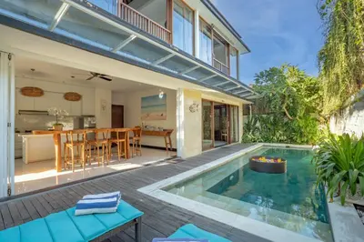 an outdoor patio with a swimming pool and a house at Lacasa3 Villa Legian With Butler in Legian