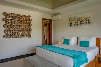 a bedroom with a large white bed and two pictures on the wall at Lacasa3 Villa Legian With Butler in Legian