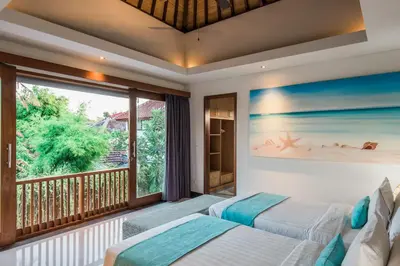 two beds in a bedroom with a balcony at Lacasa3 Villa Legian With Butler in Legian