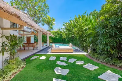 an outdoor patio with a couch and grass at Villa Indigo - 5-BDR with huge pool and garden in Seminyak