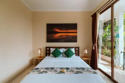 a bedroom with a bed and a large window at Umah Kita in Seminyak