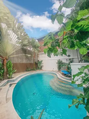 a swimming pool in a yard with trees at Umah Kita in Seminyak