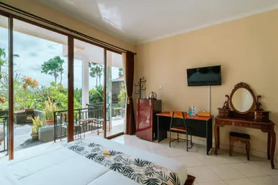 a bedroom with a bed and a desk and a mirror at Umah Kita in Seminyak