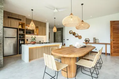 a kitchen and dining room with a wooden table and chairs at Coastal Elegance 4BR Villa, 400m to Finns in Canggu