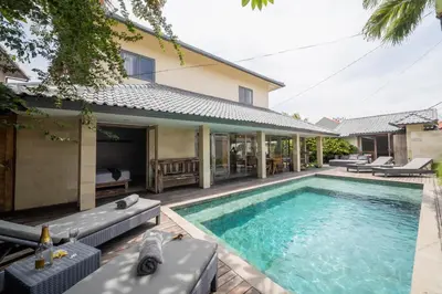 a swimming pool in front of a house at Villa Amana Seminyak in Seminyak
