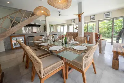 a dining room with a long table and chairs at Villa Amana Seminyak in Seminyak