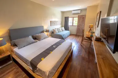 a bedroom with a large bed and a living room at Villa Amana Seminyak in Seminyak