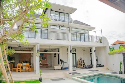 a villa with a swimming pool and a house at Berawa Homestay in Canggu