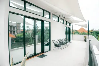 a balcony with chairs and windows in a building at Berawa Homestay in Canggu