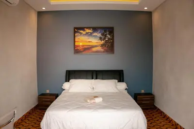 a bedroom with a bed with a painting on the wall at Berawa Homestay in Canggu