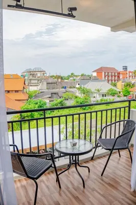 a balcony with two chairs and a table with a view at Berawa Homestay in Canggu