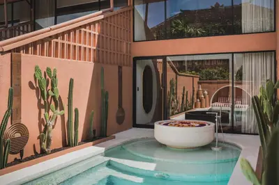 a bath tub in the corner of a building with cactus at Cyrus Villa Seminyak by Ini Vie Hospitality in Seminyak