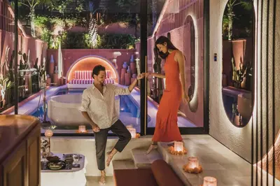 a woman holding the hand of a man in a room at Cyrus Villa Seminyak by Ini Vie Hospitality in Seminyak