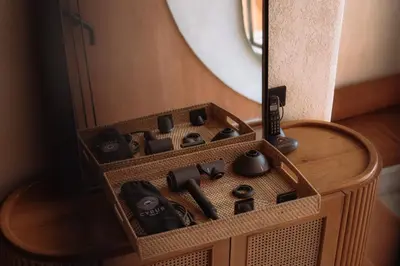 a wooden box filled with black controllers in front of a mirror at Cyrus Villa Seminyak by Ini Vie Hospitality in Seminyak