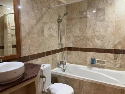 a bathroom with a toilet and a sink and a tub at Coastal Suite at Jayakarta Residence in Seminyak
