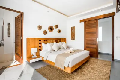 a bedroom with a large bed with a wooden headboard at Villa GoodFellas by BaliSuperHost in Seminyak