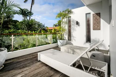 a balcony with a white chair and a table at Villa GoodFellas by BaliSuperHost in Seminyak