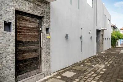 a wooden door on the side of a brick building at Villa GoodFellas by BaliSuperHost in Seminyak