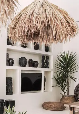 a living room with a shelf with vases and a plant at Villa Obao in Seminyak