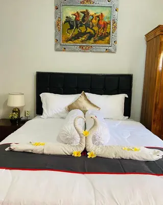 two swans made out of towels on a bed at Guest House Pondok Puspa Ayu in Kuta