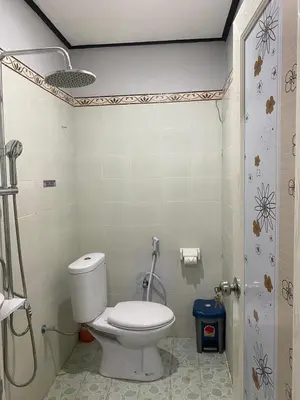 a bathroom with a toilet and a shower at Guest House Pondok Puspa Ayu in Kuta