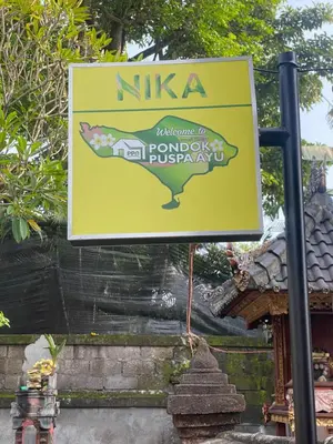 a sign for a temple with a picture of a fish at Guest House Pondok Puspa Ayu in Kuta
