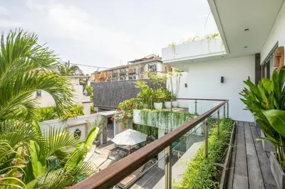 an apartment balcony with plants and a patio at Incredible 4BR Villa 5 mins walk to the beach in Canggu