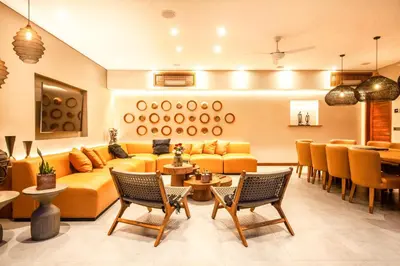 a living room with a yellow couch and chairs at Elegant 6BR Villa, Canggu, 400m to Finns Beach in Canggu