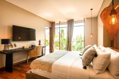 a bedroom with a bed and a desk and a television at Elegant 6BR Villa, Canggu, 400m to Finns Beach in Canggu