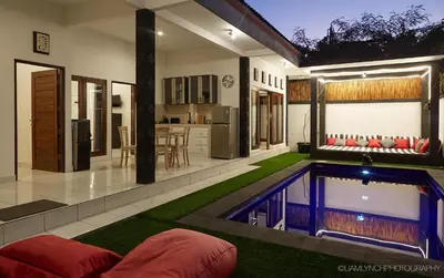 a house with a swimming pool in the yard at Villa Ari in Seminyak