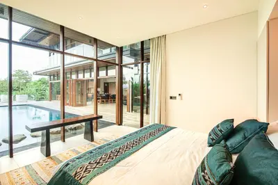 a bedroom with a bed and a swimming pool at Marvelous 6BR, Panoramic Views, Ultimate Luxury in Canggu