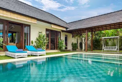 a swimming pool in front of a villa at Villa Intan in Legian