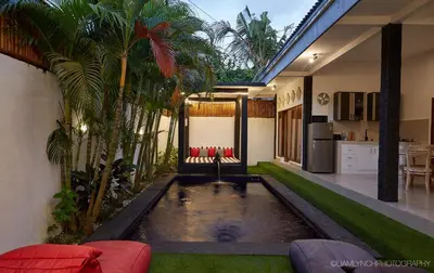 a house with a pond in the middle of a yard at Villa Kaya in Seminyak