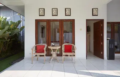 a patio with two chairs and a table at Villa Kaya in Seminyak