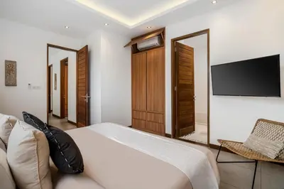 a bedroom with a bed and a flat screen tv at Villa Ara by BaliSuperHost in Seminyak