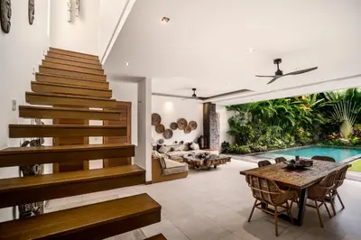 an open living room with a staircase and a pool at Villa Ara by BaliSuperHost in Seminyak