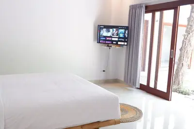 a bedroom with a bed and a flat screen tv at Villa Bristol in Seminyak