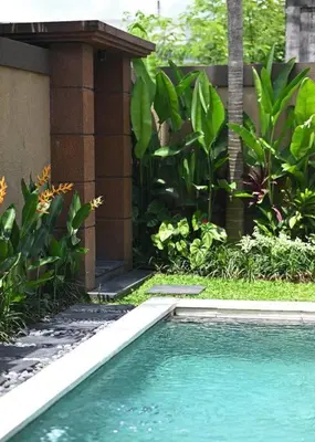 a swimming pool in front of a house at Villa Searenity Seminyak in Seminyak