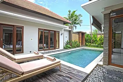 a villa with a swimming pool and a house at Villa Searenity Seminyak in Seminyak