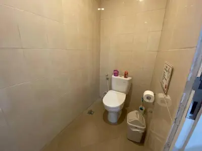a small bathroom with a toilet and a trash can at Villa Dharsan in Seminyak