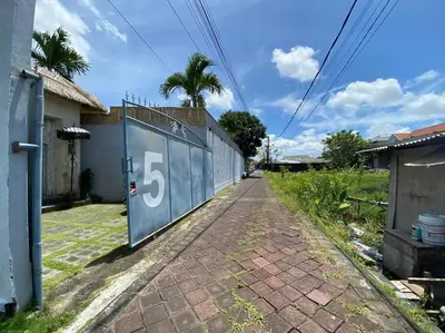 a fence with the number on it next to a street at Villa Dharsan in Seminyak