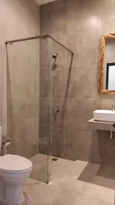 a bathroom with a shower with a toilet and a sink at Rabasta Enjoy Kuta in Denpasar