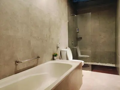 a bathroom with a bath tub and a toilet at Rabasta Enjoy Kuta in Denpasar
