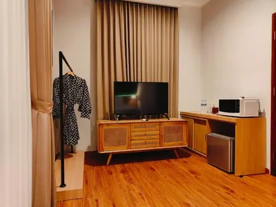 a room with a flat screen tv on a wooden entertainment center at Rabasta Enjoy Kuta in Denpasar